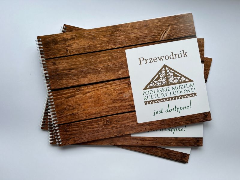 Okładka przewodnika po muzeum z napisami w brajlu i czarnym druku Okładka przewodnika po muzeum z napisami w brajlu i czarnym druku