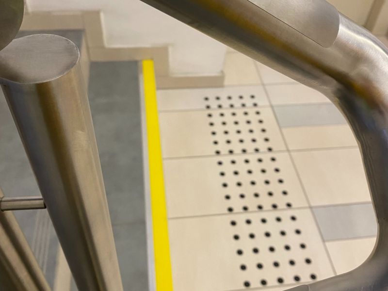 kontrastowe oznaczenia schodów i brajlowska tabliczka na poręcz  kontrastowe oznaczenia schodów i brajlowska tabliczka na poręcz