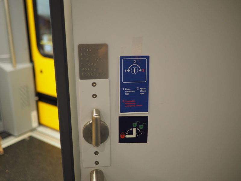 Metalowa, brajlowska tabliczka z opisami pomieszczeń i przycisków w wagonach kolei węgierskiej Metalowa, brajlowska tabliczka z opisami pomieszczeń i przycisków w wagonach kolei węgierskiej