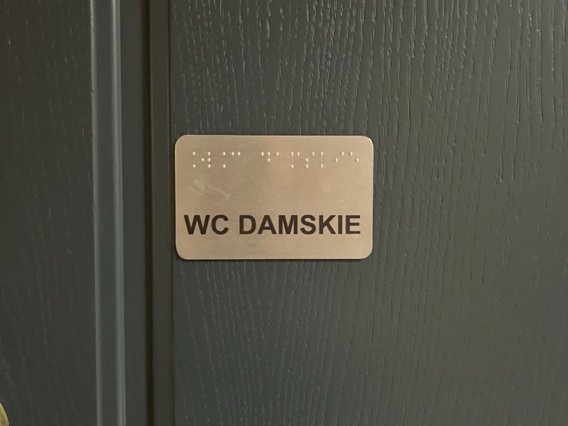 Tabliczka informacyjna w czarnym druku i w brajlu Tabliczka informacyjna w czarnym druku i w brajlu